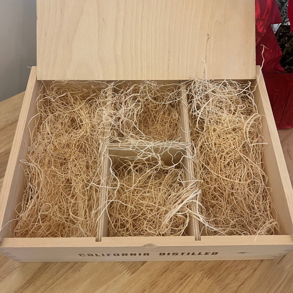 An open wooden gift box filled with straw, designed to hold alcoholic beverages such as wine.
