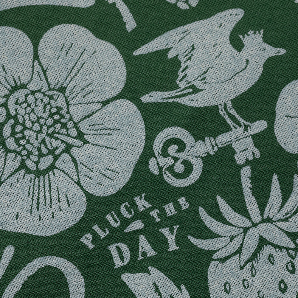 Macro detail of the green bandana's floral and key motifs