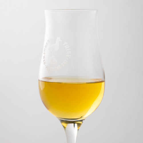Strawberry Thief tasting glass filled with amber spirit